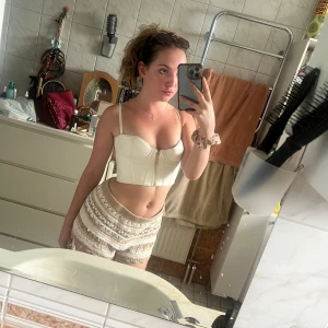 Vit bustier top från Meshki  - Läder imitation  Australiensk strolek 8 (XS/S eller 34)   Säljer då den aldrig kom till användning, perfekt för A-B kupa  (ungefär 70 i omkrets)  Har även i mindre storlek (se nästa inlägg)    Originalpris 1200 SEK   Köpare betalar frakt