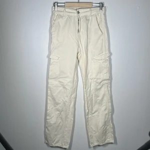 Cargopants - Cremefärgade cargobyxor Aldrig använda, blivit lite skrynkliga bara bland kläderna.  Nyskick! Skit snygga på, sitter fint där bak. 
