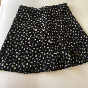 Svart blommig kjol från HM, säljer då den inte kommer till användning Sitter just under naveln och passar mig som brukar ha storlek 32💕🌸 Priset går att diskutera 