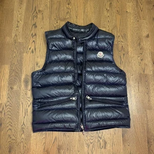 Moncler väst - Hej, säljer denna riktigt feta moncler väst för bara 3000 kr. Den är i topp skick förutom dragkedjan som är sönder! Bara att skriva till mig ifall du har nån fråga, priset är inte hugget i sten!