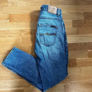 Riktigt snygga nudie jeans. Skön passform i storlek w29 L30 Riktigt snygga till sommaren i en ljusare blå färg. I fint skick , med lite slitningar fram som bara är en snygg detalj!