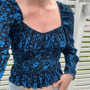 Zara blus - Mörkblå och svart blommig blus från zara med resår volang och vringning