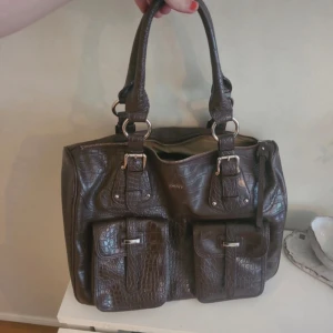 Väska från DKNY - Söt väska från DKNY, köpt secondhand. Super bra skick dock så finns det lite fläckar från färgpennor innuti väskan.