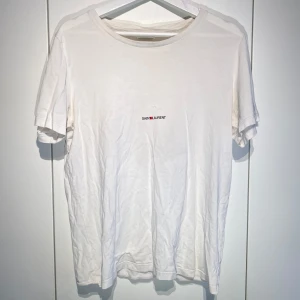 Saint Laurent T-shirt Vit - Hej, säljer den populära Saint Laurent T-shirten med tryck på magen i vitt. Använt och slitet skick med 2 stora defekter, bild i DM & därav det billiga priset. Storlek L men passar även M. Nypris 5400kr. Har box, brev & tagg från köp. Pris kan diskuteras. Hörs i DM! 