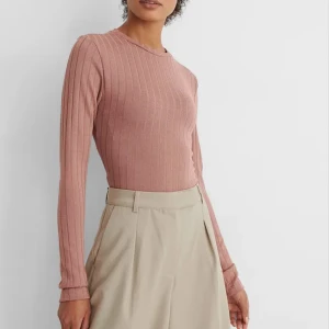 Rosa topp från NA-KD - En rosa topp från NA-KD med delvis öppen rygg och knut vid ryggen. Tröjan är i bra skick då jag endast testat den enstaka gånger, lappen är fortfarande kvar. Tröjan är i storlek M men är lite liten i storleken. 