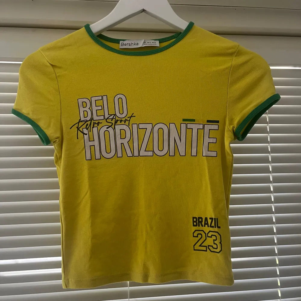 Sötaste brazil t-shirten från Bershka❣️ fint skick, texten har bara blivit lite stripig från tvätten☺️. T-shirts.