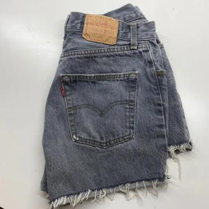 Levis Original denim shorts - Levis Original denim shorts. 75/76 cm runt midjan, 32 cm långa och 26 cm från mitten och ut till sidan. Shortsen är i fint skick. Lite noppriga inuti fickorna men inget som syns utanpå + bruna märket slitet pga tvätt. Pris kan självklart diskuteras!