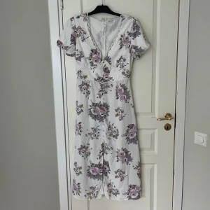 Blommig klänning - Säljer nu min superfina klänning i stl 38. 🪷🌸💐 Köpt på Zalando. Plagget är i gott skick och sitter väldigt fint på. Den har en slits i mitten och små knappar. DRÖM-KLÄNNING! 🩷