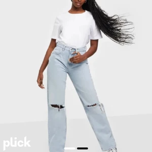 Blå jeans - Jeans från Gina Tricot med hål på knäna. Hålen har töjts men i övrigt är byxorna i bra skick🤍