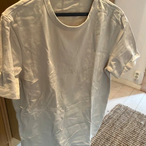 Beige-shirt från A Day's March - En enkel och stilren beige t-shirt från A Day's March. T-shirten har korta ärmar och en rund halsringning.