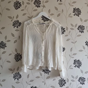 Zara basic, vit blus, Strl: M - Zara basic, tunn vit blus i storlek medium. Knäppning och dragsko i fram samt vid ärmarns och sött prickigt mönster. Fint skick!