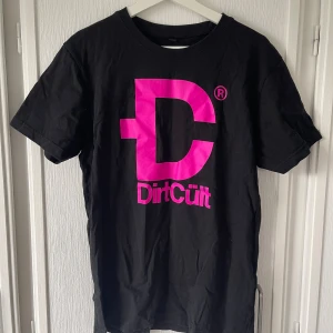 Svart DirtCült t-shirt med tryck - Snygg DirtCült tröja som jag bara har använt några enstaka gånger. Tröjan har inte blivit mer använd än så då den är för stor för mig. I mycket bra skick. 