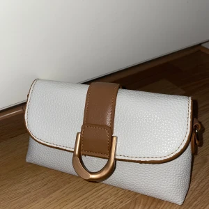 Brun och vit clutch väska - Gullig clutch väska, aldrig använts innan. Köpte på en marknad utomlands, vet ej märket.  Köp gärna!💕