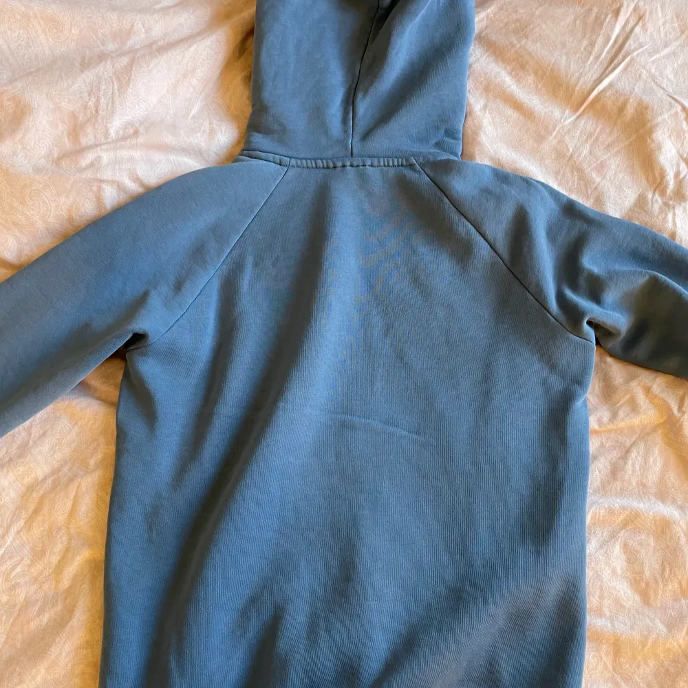 Mycket fin blå hoodie från Peak Performance. Den är använd men är i fint skick. Något liten i storleken. Nypris 1200.. Hoodies.