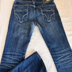 Lågmidjade bootcut jeans - Säljer dessa sjukt snygga oanvända lågmidjade vintage bootcut jeansen då dom var för små för mig. Superfint mönster och fin färg🤍Stl 32/34 ! Köpta för 800kr  Märke - Miss2&F