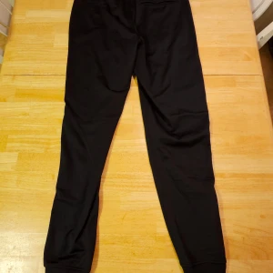 Under Armour träningsbyxor  - Svarta sköna träningsbyxor från Under Armour, använda vid ett tillfälle. Dragkedja i sidofickorna. Polyester. Storlek: S/M