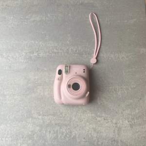 En rosa kamera som skriver ut foton,använd ett fåtal gånger och i kameran ingår 9 stycken fotopapper! Om du vill köpa till finns det att köpa på clas Ohlson. Kameran har ett värde runt 800 kr.