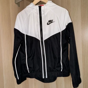Nike jacka svartvit dam - Aldrig kommit till användning. Nyskick, väldigt fin tunn vår och sommar/vind/träningsjacka. Storlek S men passar XS. Köpt för ca 849kr.