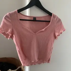 Säljer denna rosa t-shirt med v-ring i något stickat material. Den är lite noppig också men nästan aldrig använd.