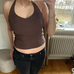 Halterneck topp - Brun topp med knytning runt halsen och öppen i ryggen. Den är knappt använd och i nyskick. Storleken är XS men passar mig som brukar ha S💕