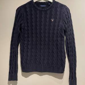 Mörkblå kabelstickad tröja från Gant, i storlek 158/164. 