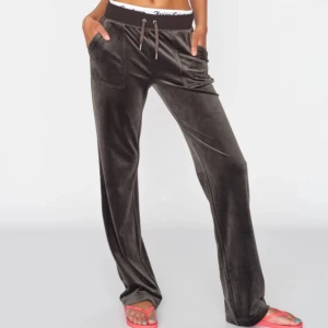Juicy Couture byxor - Juicy mjukisbyxor i bra skick i en snygg mörkgrå färg. Fickor med knappar på rumpan.