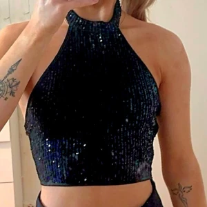 NY festtopp paljetter stl XS - Helt ny festtop med paljetter. Helterneck. Svart. Dragkedja i sidan och knappar i nacken. Stl XS. 