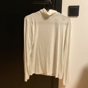 Turtleneck  - Vit långärmad tröja, något genomskinlig.