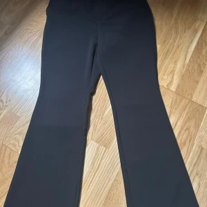 ONLY kostymbyxor storlek M/längden 32 - Snygga svarta byxor med smal passform och utsvängda ben. Byxorna har en klassisk design och är perfekta för både vardag och fest. Använda fåtal gånger.