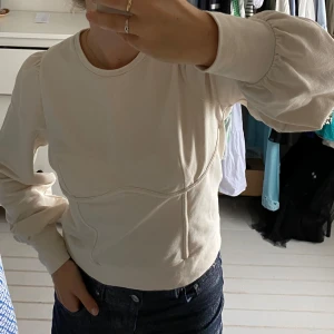 Sweatshirt med detalj - Sweatshirt i stretchigt material med detalj under bröstet och puffärmar