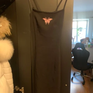 Klänning - Svart klänning med en rosa fjäril