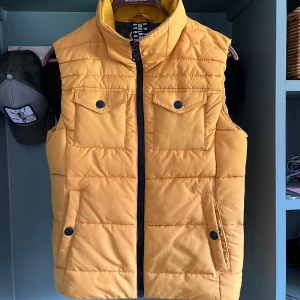 S.Oliver väst - Säljer min gula S.Oliver väst för 249kr. Använd endast ett fåtal gånger och är i väldigt bra skick. Huvan är avtagbar och storleken är S. 