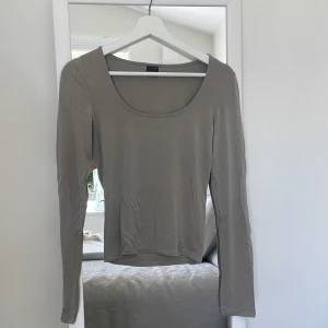 Olivgrön basic tröja med slits - En basic U-ringad tröja med slits.