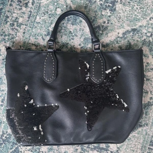 Väska  - Säljar denna väska men två stjärnorna på. Stjärnorna är svarta med går att ändra till silver eftersom det är drag paljetter. Väskan är som ny och original är 545kr