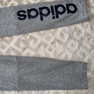 Gråa adidastights med svart tryck - Storlek M men kan passa S