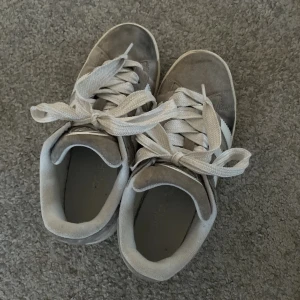 Adidas campus 00s/ grå - Säljer dessa as snygga campus00s grå. Jag har använt de en del ggr och de syns på de.,de har fått fläckar från regnet men har mocka rengöring till de så tvättar innan ja skickar! Även en slitning längst bak på ena skon se sista bilden! 💗