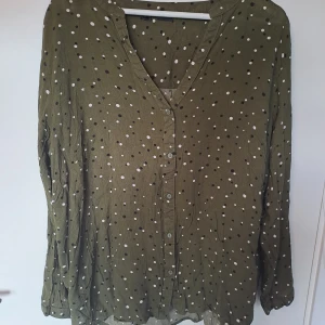 Blus Bodyflirt - Säljer denna fina blus I en olivgrön nyans, med prickar och små stjärnor!
