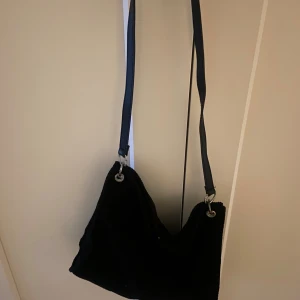 Svart axelväska - En svart axelväska med justerbar rem i manchester, myxket rymlig men tyvärr aldrig använd💕
