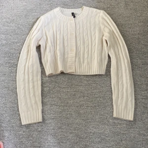 Stickad kofta - Krämvit stickad kofta från HM. Den är kabelstickad och har knappar. Lite mer kroppd, inte oversized eller så. Väldigt mjuk och skön