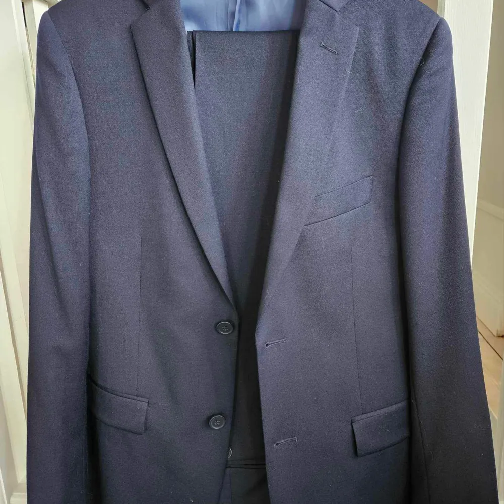 En snygg marinblå kostym. Endast använd vid enstaka tillfällen.  Storlek 46 regular i kavajen  Storlek W29 L32 i byxorna. Kostymer.