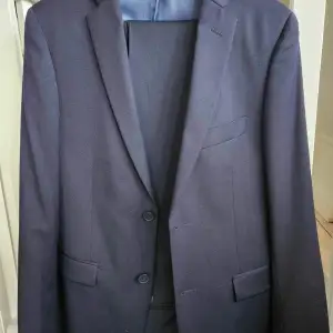 En snygg marinblå kostym. Endast använd vid enstaka tillfällen.  Storlek 46 regular i kavajen  Storlek W29 L32 i byxorna