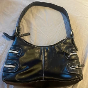 Vintage väska - Axelremsväska i svart läder, får plats med mycket då det inte är fake fack på sidorna