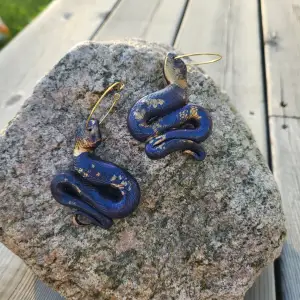Polymer clay drop and dangle statement earrings shaped as snakes. Crafted by hand.