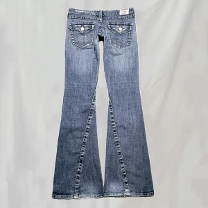 Lågmidjade jeans - Midja:78 innerben:81 Lågmidjade jeans från True Religion. Flare/ bootcutmodell. Storlek w27. Bilden där jag har de på är tagen i dagsljus. Slitningar är del av design, eventuellt några av ålder. Nötta bakre fotändar, överlag mycket fint skick!🤍