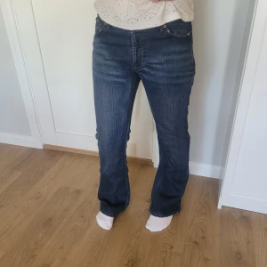 Lågmidjade Jeans  - Lågmidjade jeans från H&M Divided i mörkblått. Modellen heter girls bootcut. Innebenslängden är 83 cm. Som referens är jag 173 cm. Jeansen är i gott skick förutom att det är ett litet hål längst ner på ena benet. Vid frågor är det bara att skriva:)