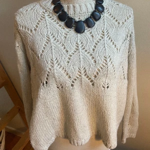 Stickad tröja  - Stickad tröja med hålade mönster,  Ljusgrå/beige. Passar storlek XS-M beroende på hur man vill att den ska sitta. 
