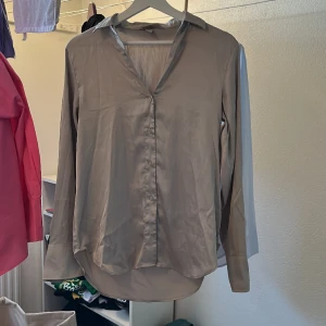 Satin skjorta - Satin skjorta i champagne färg. Väldigt skön men har så många skjortor.