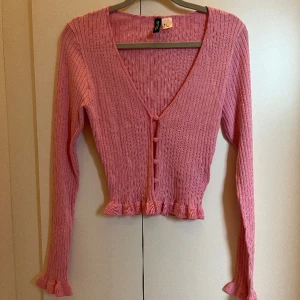 Kofta  - En rosa kofta ifrån Hm med volanger på ärmarna och i midjan. Aldrig använd.🩷 Bilderna blir väldigt konstiga när jag lägger in de i appen så skicka ett meddelande om ni vill ha bättre bilder.