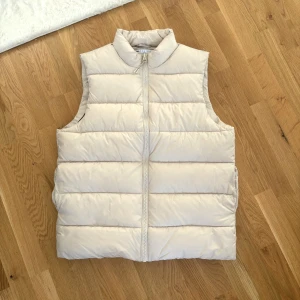 Beige väst - Beige dunväst från Asos. Knappt använd, så som ny! 