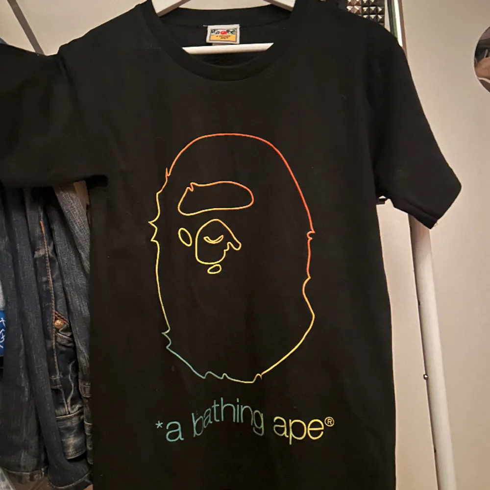 A bathing ape (Bape) T shirt som knappt kommit till använding då jag har mycket andra kläder. Rare modell på tröjan med regnbågs kanterna. Passar snyggt på mig som är 170. T-shirts.